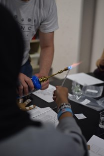 Bunsen burner burning a glass rod to analyze thermal shock
