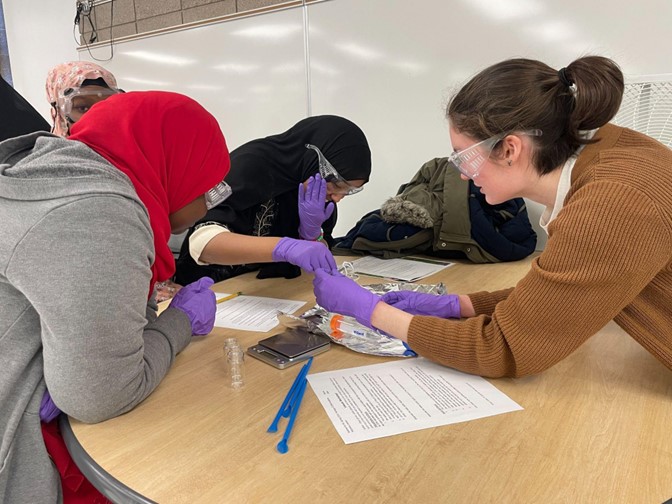 Students and an SFA volunteer work together to spool polymer "rope"