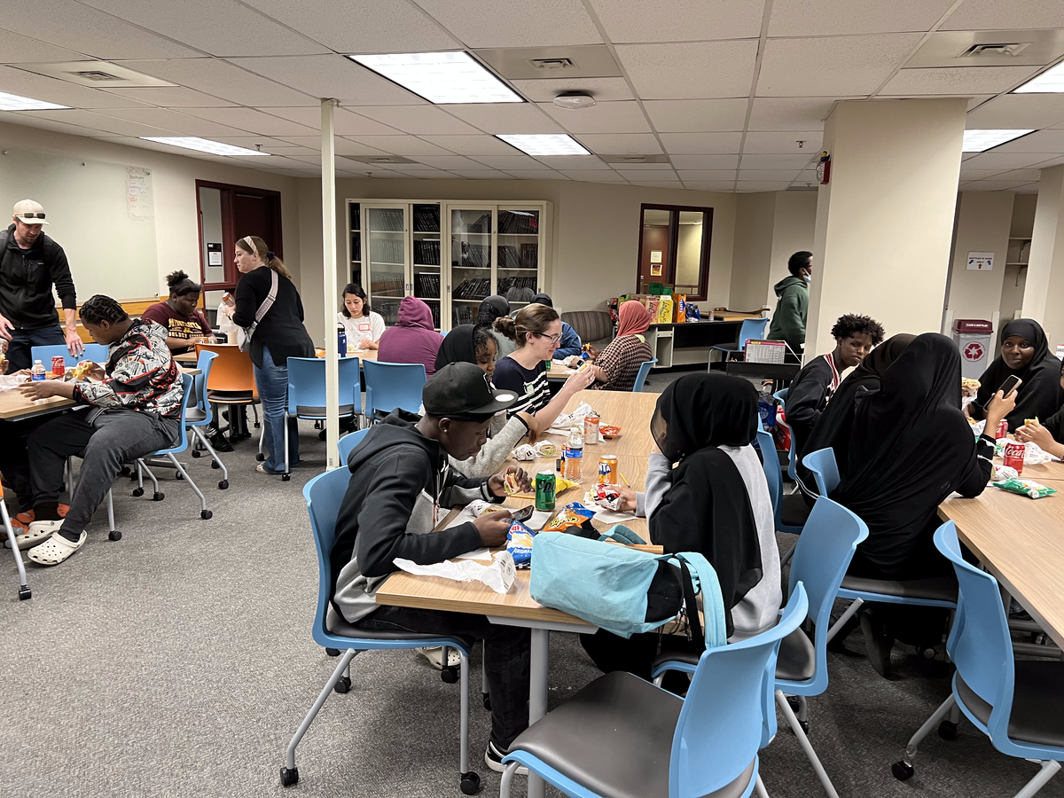 Tables of students have lunch together in the graduate student lounge. 