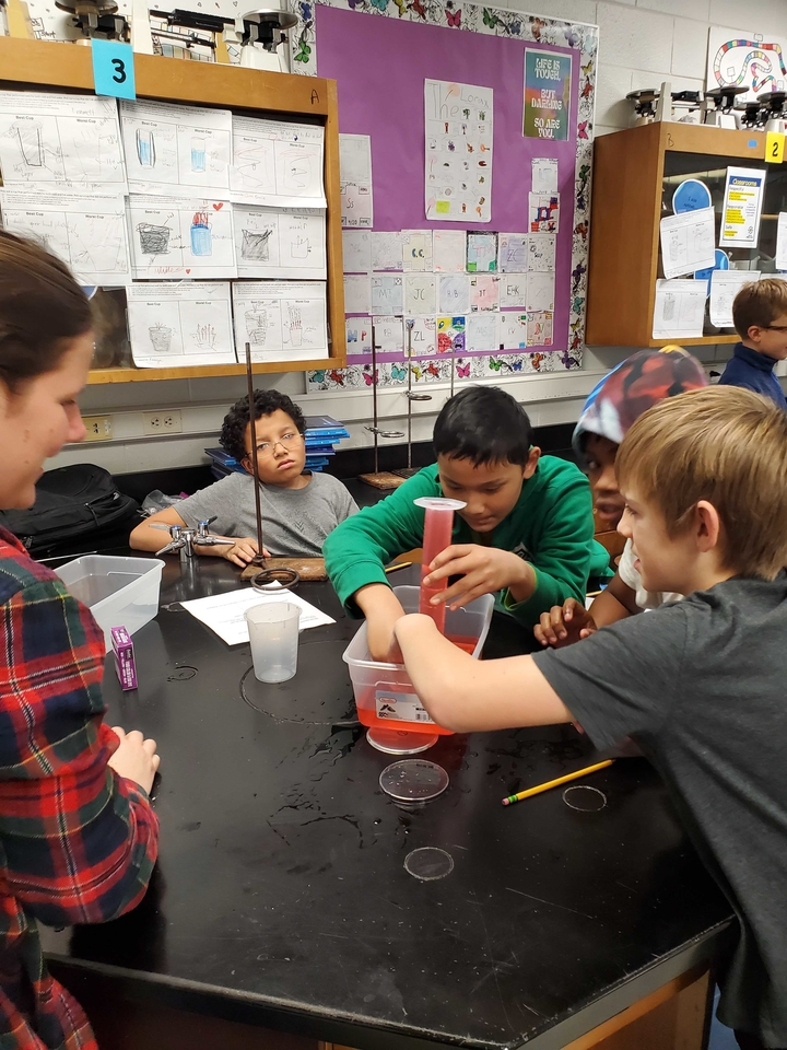 Students excitedly watching the liquid level drop as the Alka-Seltzer tablet releases carbon dioxide. 